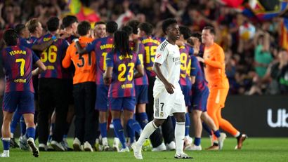 Vini during the latest El Clasico with the Barca players celebrating in the back (©Alex Caparros/Getty Images)