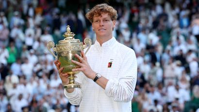 Jannik Sinner poses for a photo with the Wimbledon trophy (©Clive Brunskill/Getty Images)