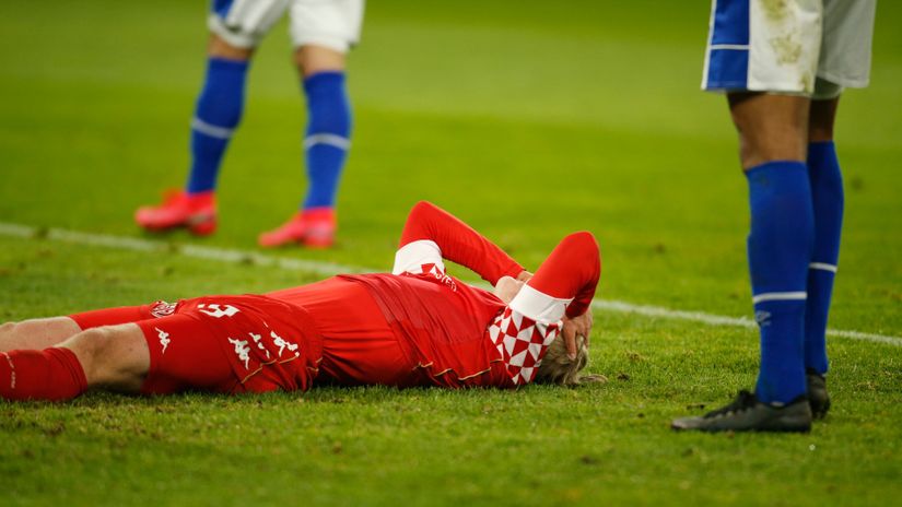 Mainz player lying on the ground between the two Schalke guys (©AFP)