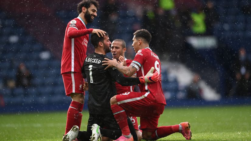 Alisson surrounded by his teammates after the crucial goal (©Laurence Griffiths/Getty Images)