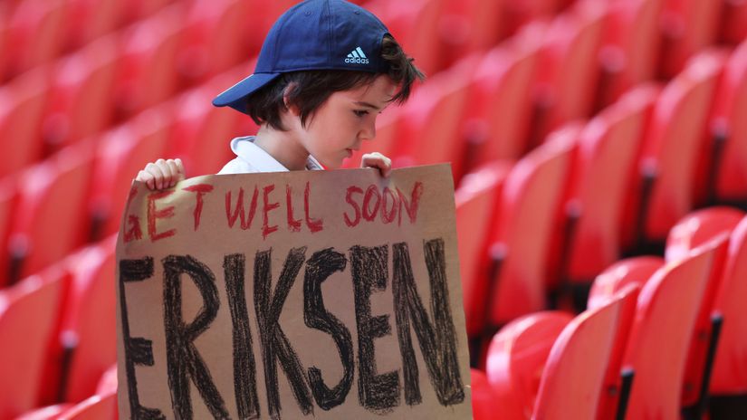 A young fan holds a banner of support for Denmark's Christian Eriksen (©REUTERS/Catherine Ivill)