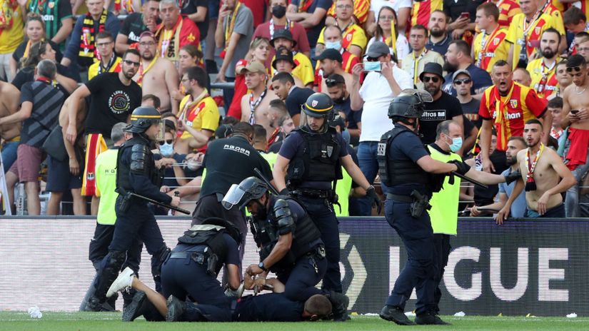 Police officers detain a fan during the match (©)