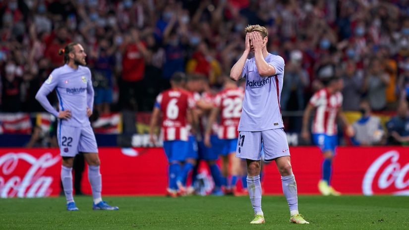 Frenkie De Jong in despair, while Atleti players celebrate in the back (©Quality Sport Images/Getty Images)
