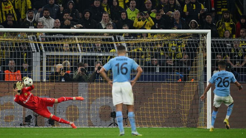 Riyad Mahrez of Manchester City has a penalty saved by Gregor Kobel of Borussia Dortmund (©Matthias Hangst/Getty Images)