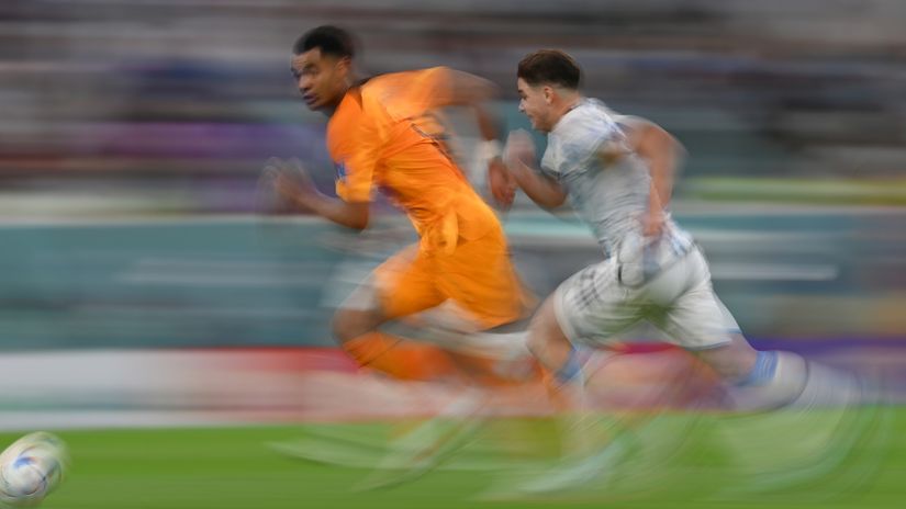 Gakpo runs past Julian Alvarez during the FIFA World Cup quarter-final clash between the Netherlands and Argentina (©Dan Mullan/Getty Images)