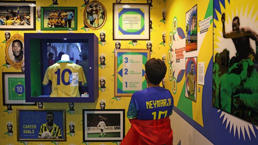 A young Brazilian supporter looks at the shirt of Pele during the FIFA World Cup Qatar 2022 (©Alex Pantling/Getty Images)