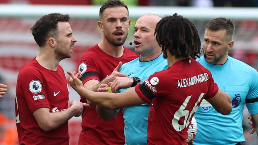 Diogo Jota, Jordan Henderson and Trent Alexander-Arnold react after Andrew Robertson is shown a yellow card by referee Paul Tierney at half time after clashing with assistant referee Constantine Hatzidakis (©REUTERS/Phil Noble)