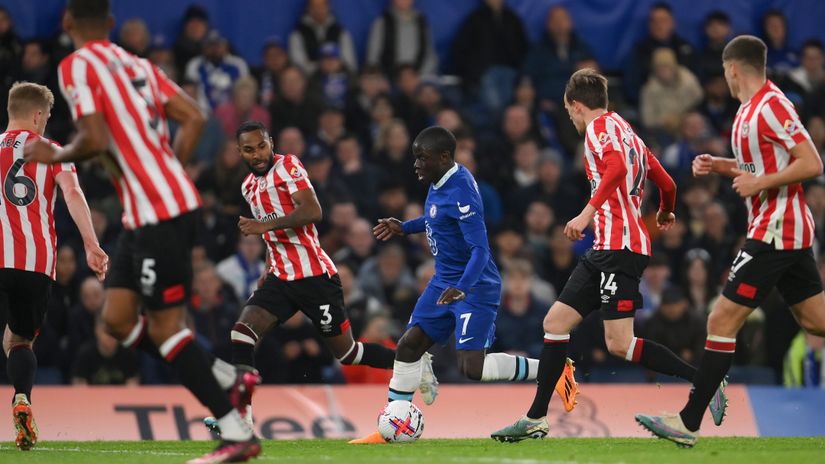 Kante runs with the ball whilst under pressure from players of Brentford (©Mike Hewitt/Getty Images)