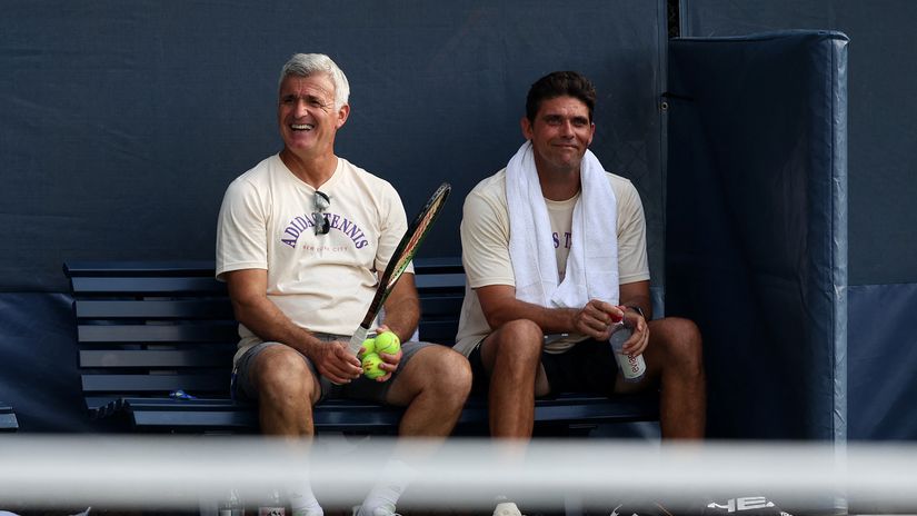 Apostolos Tsitsipas (L) and Mark Philippoussis watch on from the practice courts© AFP 