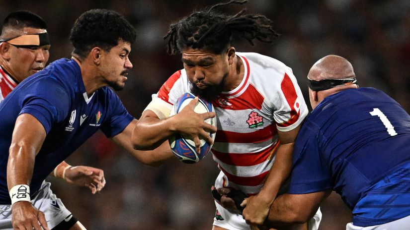 Shota Horie (C) is tackled by Samoa's loosehead prop James Lay (R) and Samoa's lock Theo McFarland (L) © AFP 