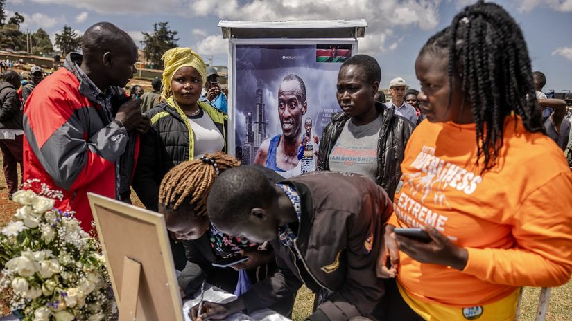 People sign a book of condolences next to a photo of Kelvin Kiptum during the beginning of the funeral proceedings to marathon runner Kelvin Kiptum in Iten © LUIS TATO / AFP