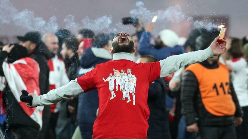 Georgian fan in jubilation, with a flare in his hand, on the pitch, celebrating the triumph (©Irakli Gedenidze/Reuters)