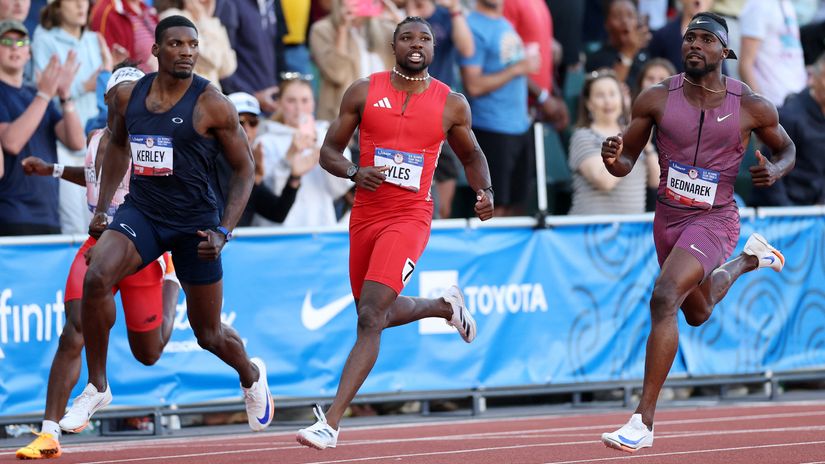 Fred Kerley, Noah Lyles and Kenny Bednarek react while crossing the finish line© AFP