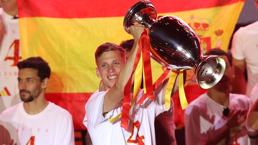 Dani Olmo holds up the EURO 2024 trophy (©Gonzalo Arroyo Moreno/Getty Images)
