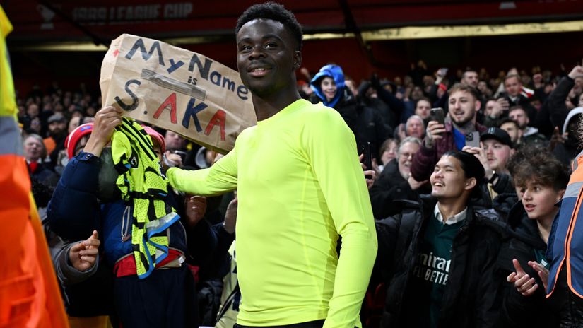Bukayo Saka poses for a photo with a fan after gifting his shirt (©Michael Regan/Getty Images)