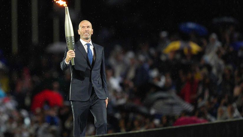 Zinedine Zidane holds the Olympic torch during the opening ceremony of the Paris 2024 Olympic Games (©Xu Chang - Pool/Getty Images)