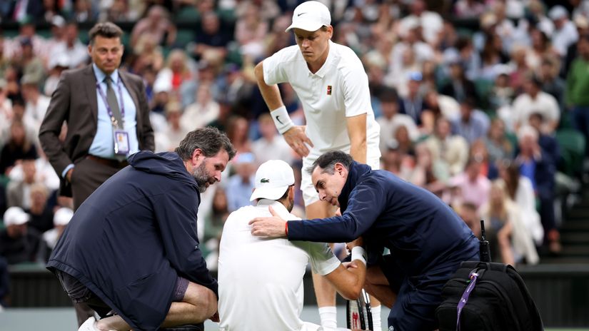 Sinner looks on as doctors are trying to help Dimitrov (©Julian Finney/Getty Images)