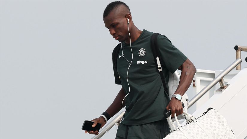 Nicolas Jackson with a bag in his hand leaves a plane (©Emilee Chinn/Getty Images)