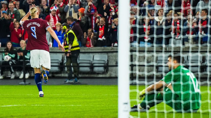 Haaland celebrates scoring his fifth goal, while Avram sits on the pitch in despair in the back (©AFP)