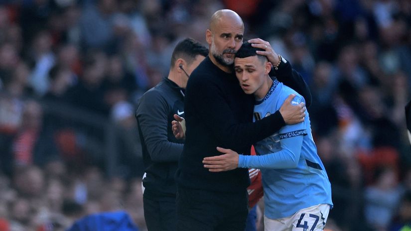 Pep Guardiola hugs Phil Foden as he leaves the pitch against Man United (©Carl Recine/Getty Images)