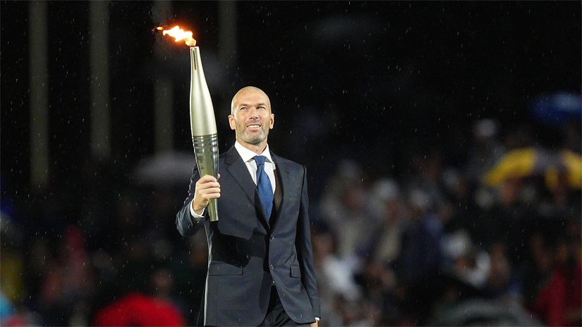 Zidane carrying the torch at the Paris Olympics opening ceremony (©Xu Chang - Pool/Getty Images)