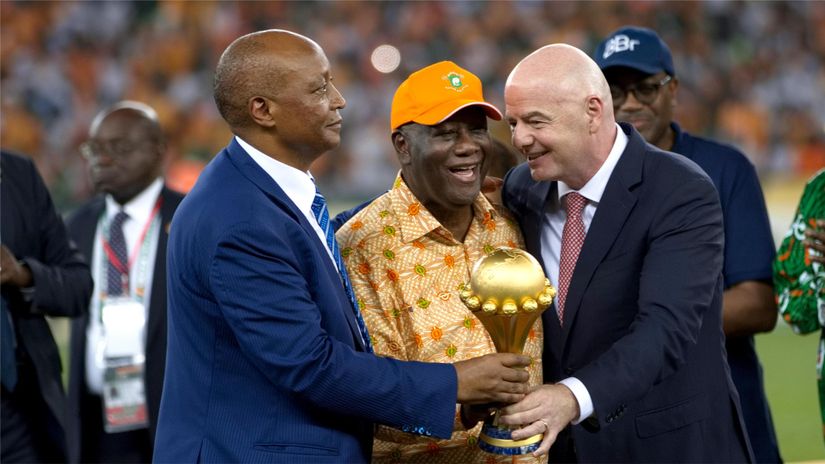 President of the CAF Patrice Motsepe (L) ,President of Ivory Coast Alassane Ouattara (C) and President of FIFA Gianni Infantino hold the AFCON trophy last year (©MB Media/Getty Images)