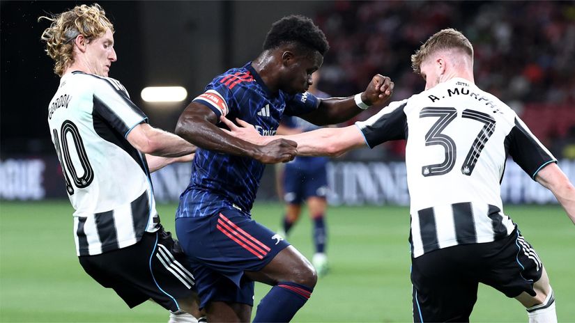Gordon (left) trying to stop Saka of Arsenal (©Yong Teck Lim/Getty Images)