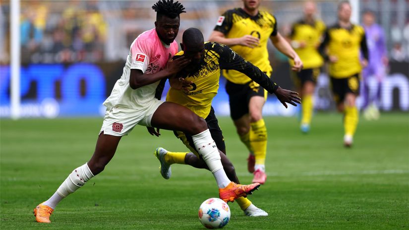 Tapsoba of Leverkusen fights for the ball with Guirassy of BVB (©Dean Mouhtaropoulos/Getty Images)