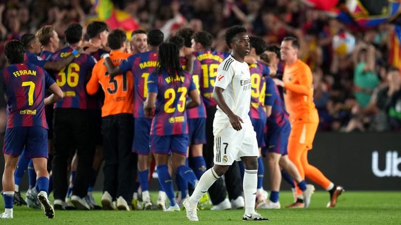 Vini during the latest El Clasico with the Barca players celebrating in the back (©Alex Caparros/Getty Images)