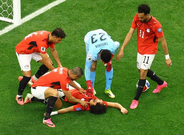Hany lies unconscious on the ground surrounded by his teammates (©Reuters/Issei Kato/Gallo Images)